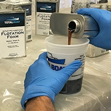 Pouring TotalBoat 2 lb. Density Flotation Foam in a 1 to 1 mix ratio, into a clean mixing cup.